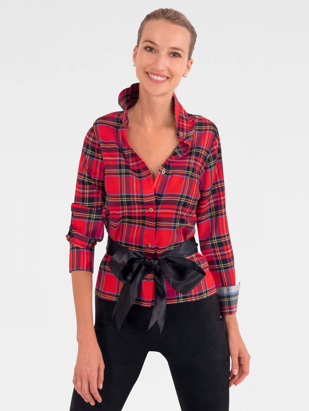 Woman wearing a red plaid shirt with a black belt on a white background